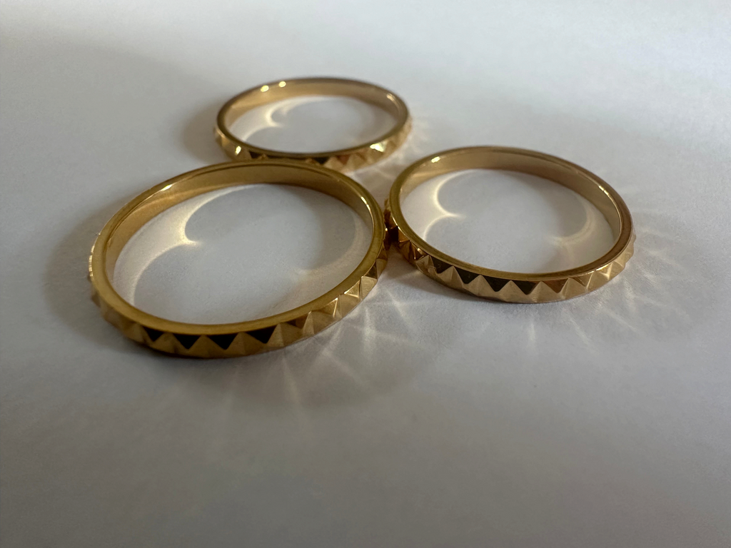Alokaluca Radiant Edge Ring featuring a gold-tone stainless steel band with a faceted, pointed geometric design.