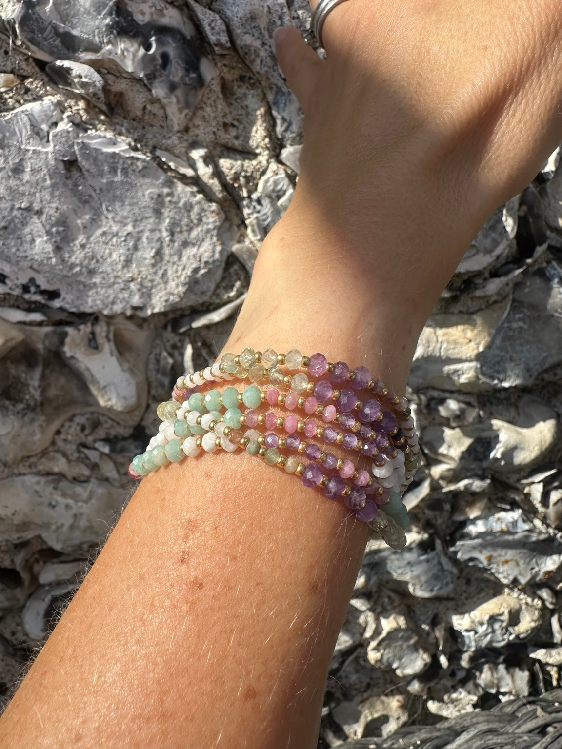 Pastel gemstone bracelets worn in a stack