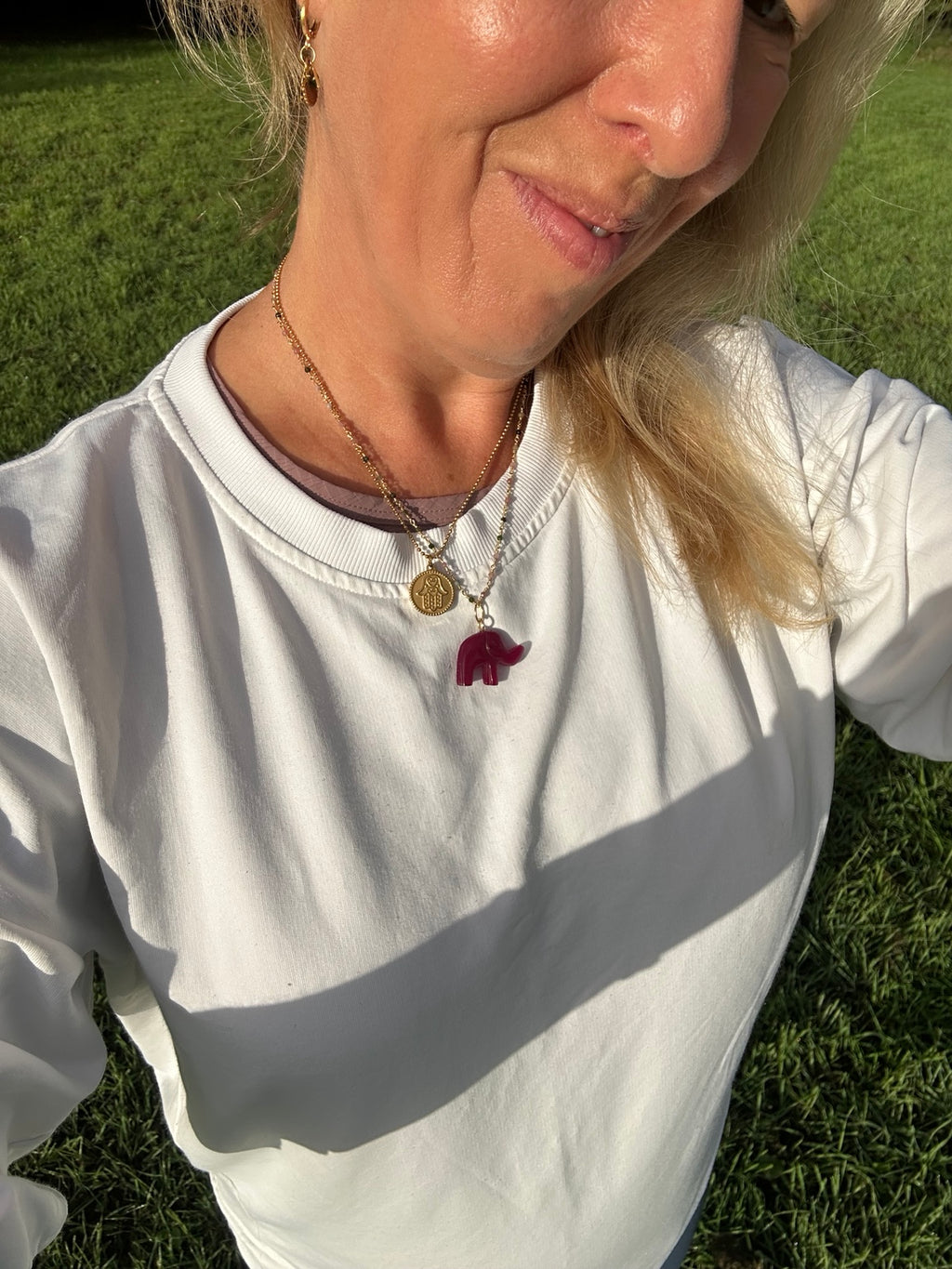 Remember Your Light hand-carved gemstone elephant necklace worn layered with gold necklaces